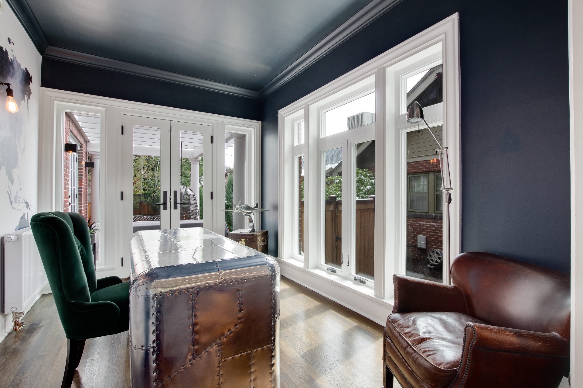 Navy sun room study with French doors and a metal desk