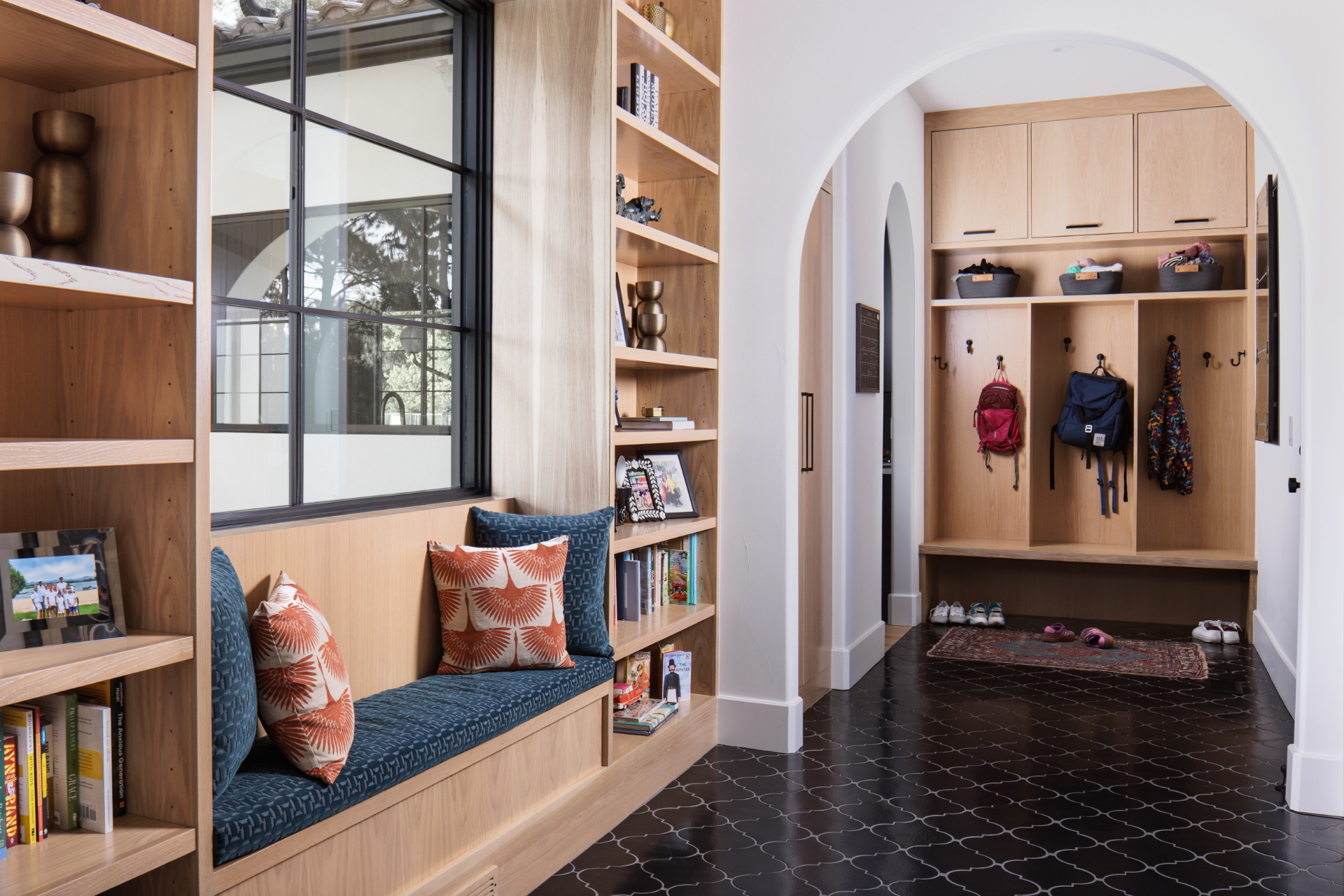 Mudroom with white oak lockers, built-in bookshelves, and a window bench