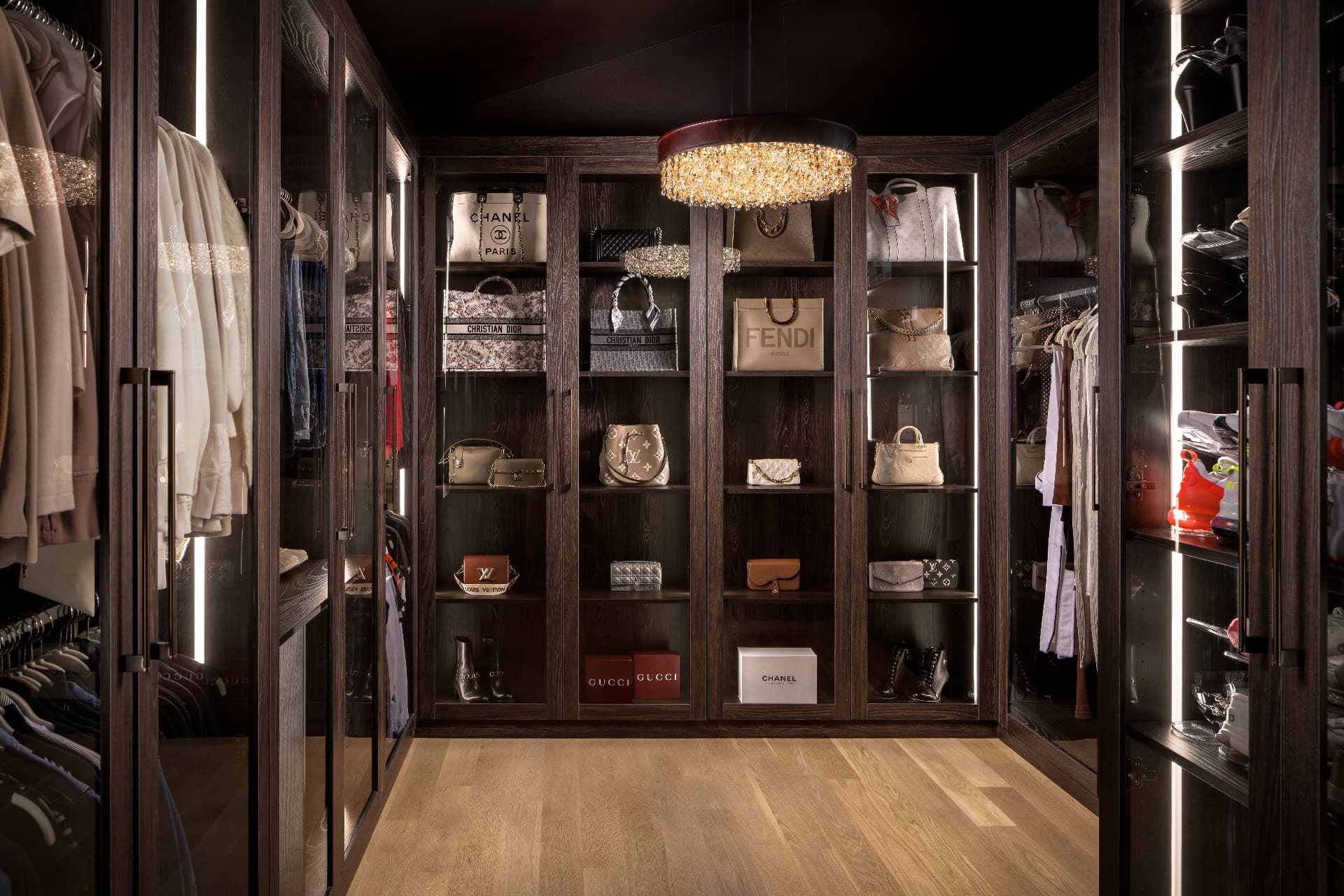 Cherry Creek closet with dark oak cabinetry, crystal chandelier, and designer shelving