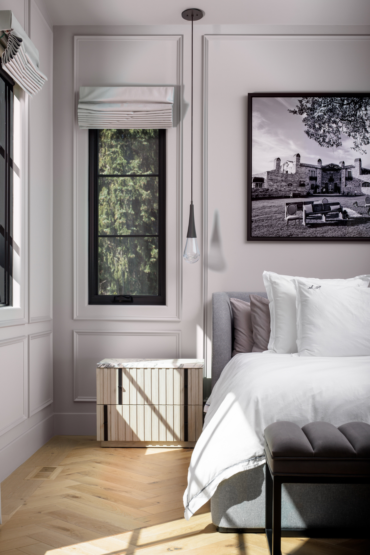 Guest bedroom with paneled walls and herringbone oak floors
