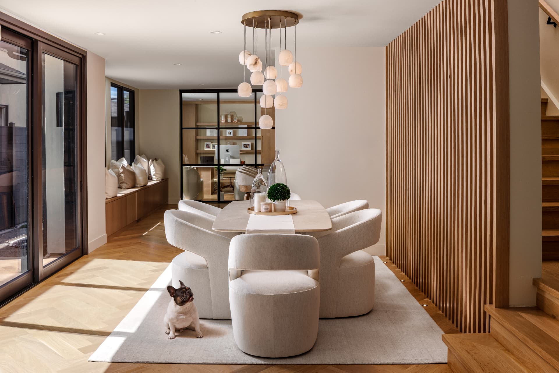Cherry Creek dining room with alabaster chandelier and white oak slat wall in sunlight