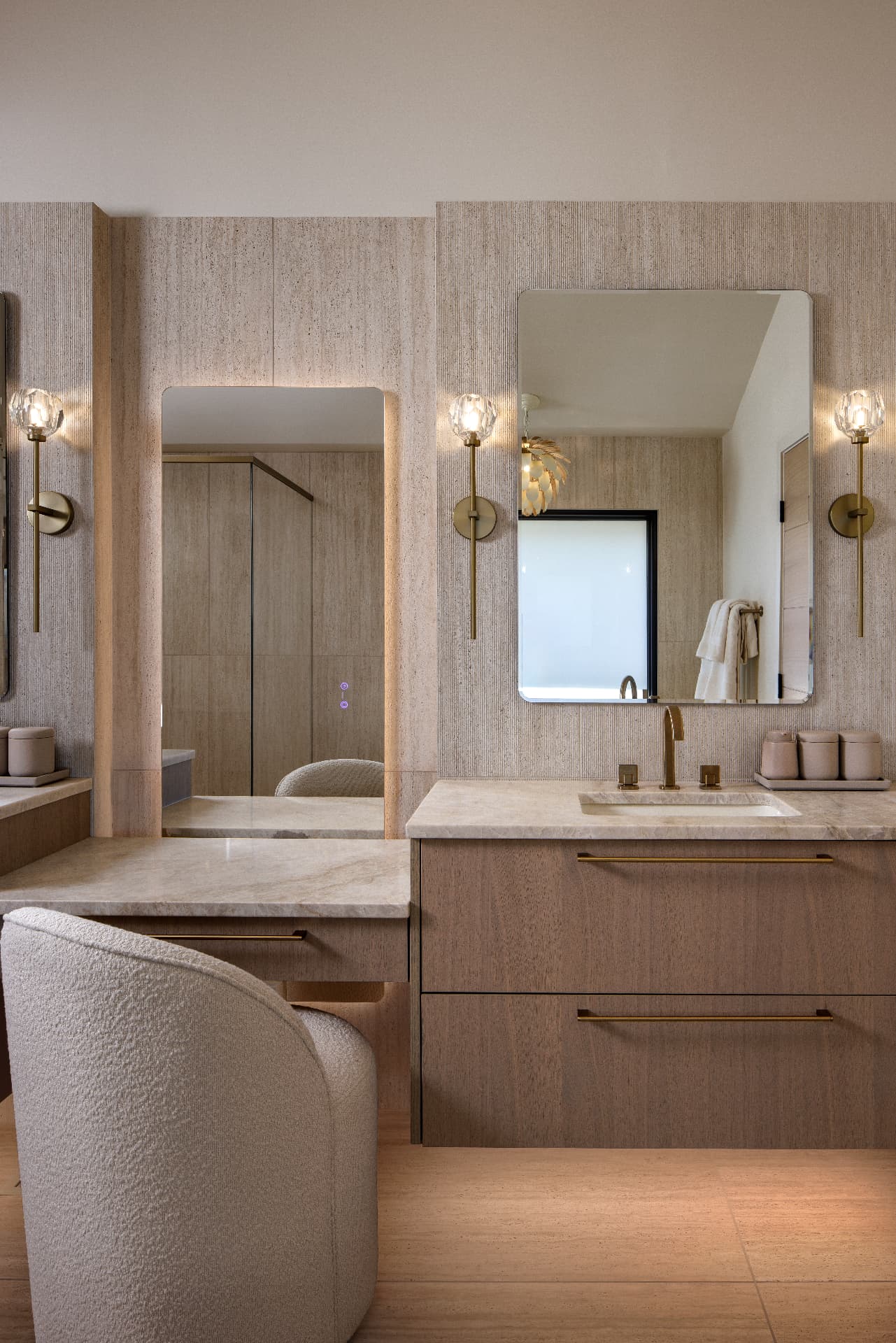 Cherry Creek primary bath vanity detail with travertine walls and brass sconces