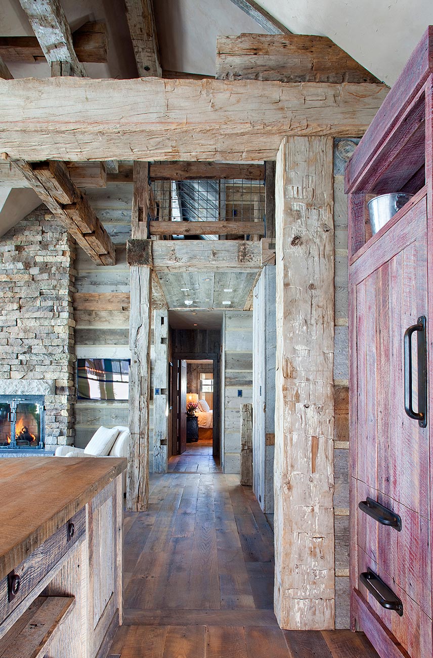 Reclaimed-timber corridor with a stone fireplace and wide-plank floors