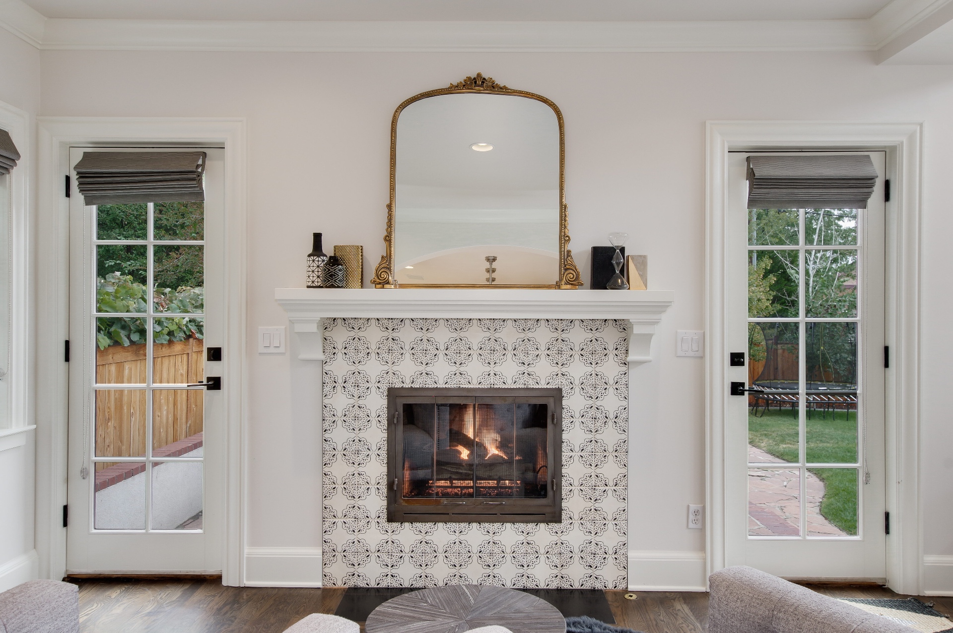 Fireplace detail with patterned tile surround and antique gilt mirror