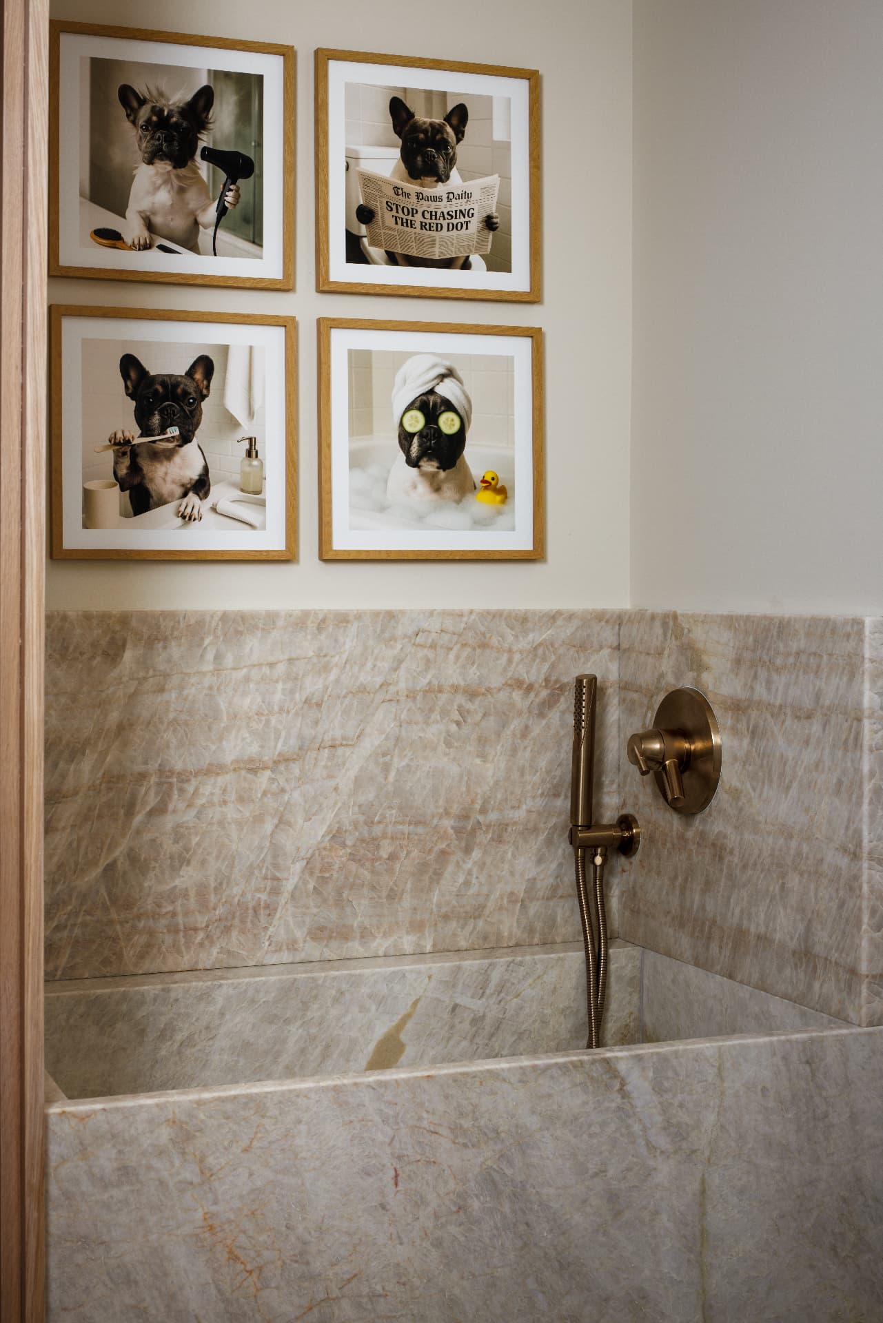 Cherry Creek dog bath with marble tub, brass fixtures, and framed pet portraits