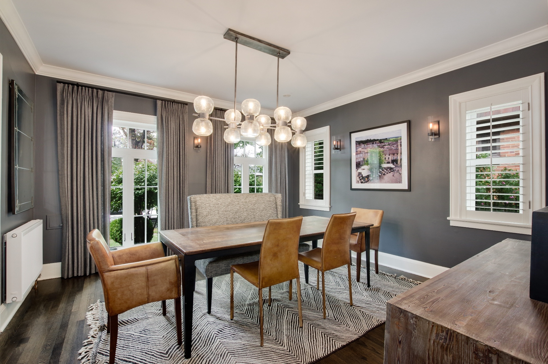Dining room with a sculptural globe chandelier and charcoal walls