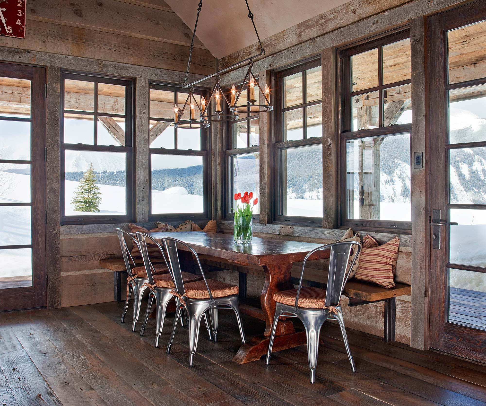 Sunlit banquette dining nook framed by snow-covered peaks