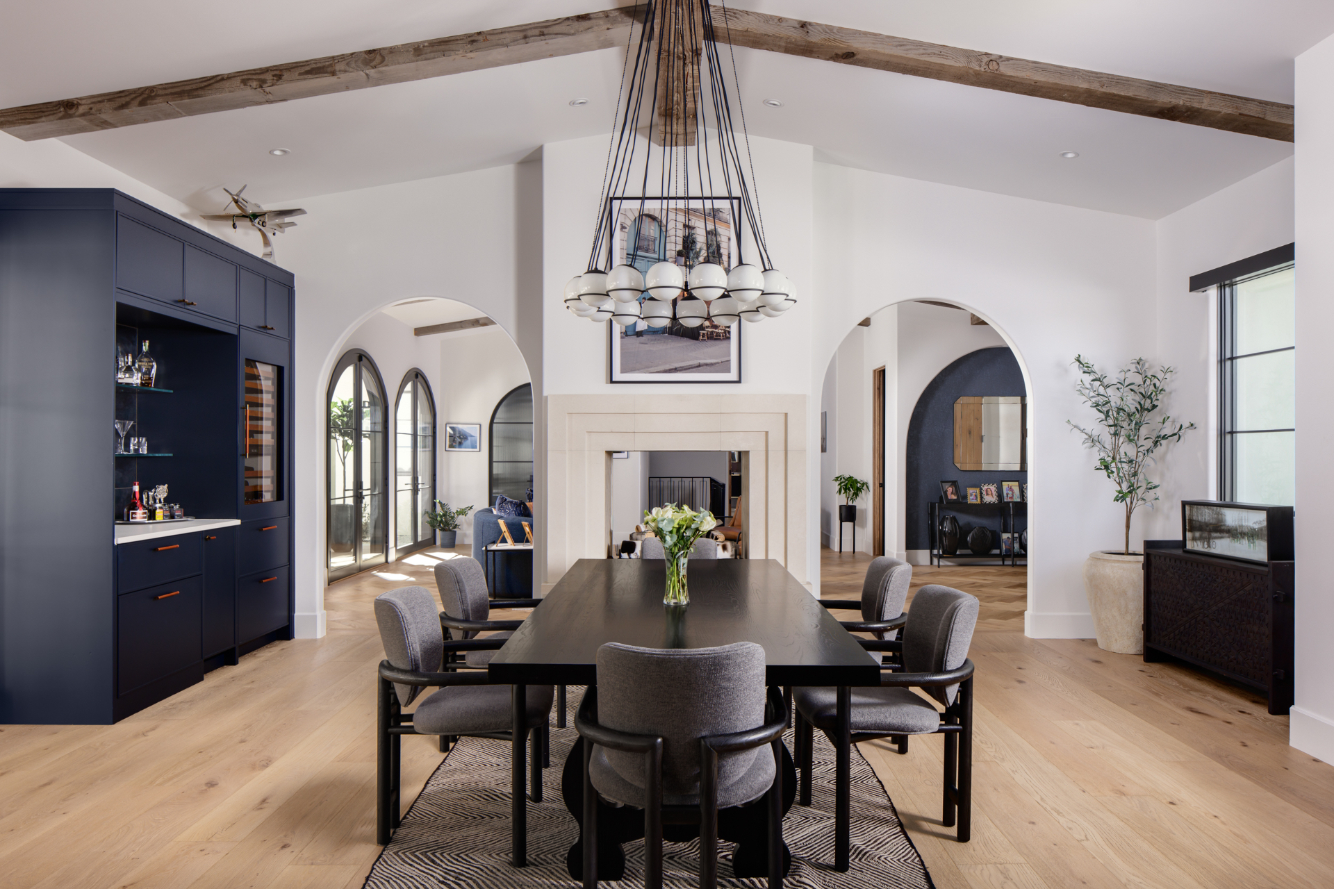 Dining room with navy bar cabinetry and a sculptural globe chandelier