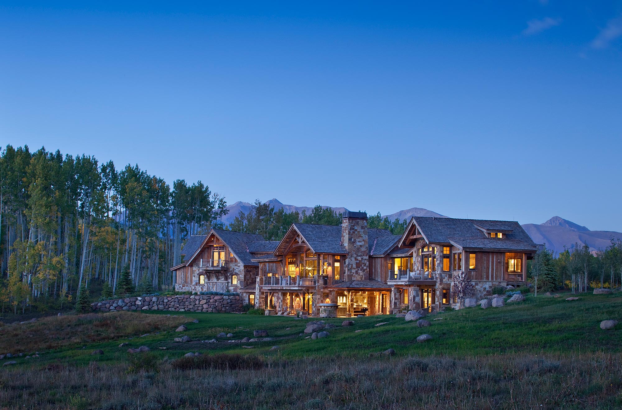 Rear elevation of the Crested Butte residence glowing at blue hour