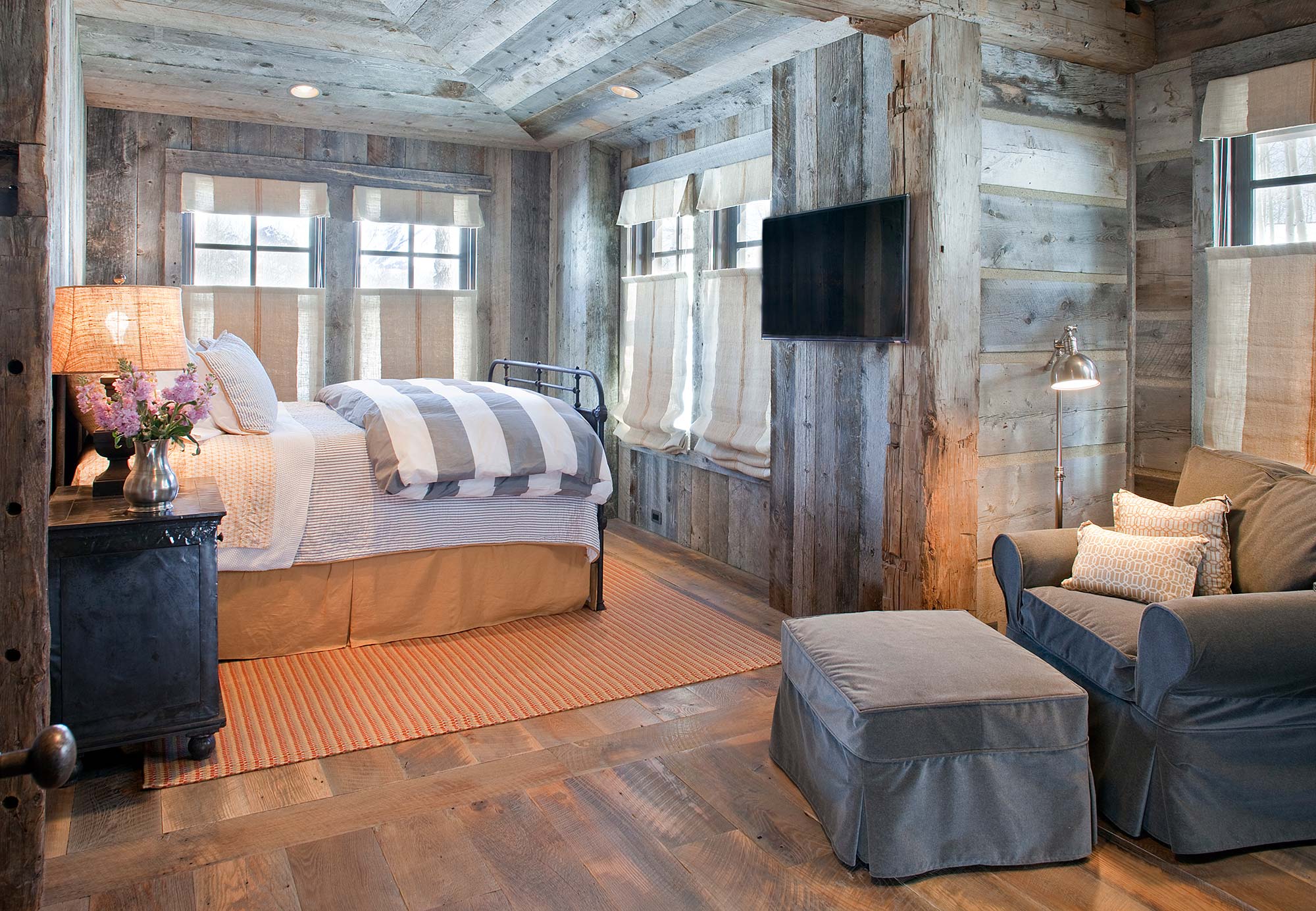 Guest bedroom clad in weathered barnwood with linen shades